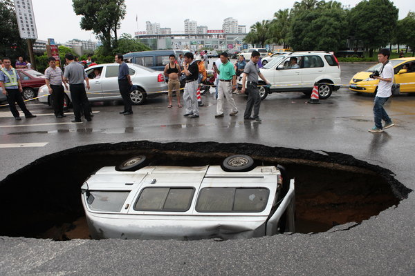 Car falls in as road in S China caves in