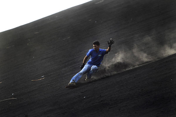 Tourists surf Cerro Negro volcano in Nicaragua