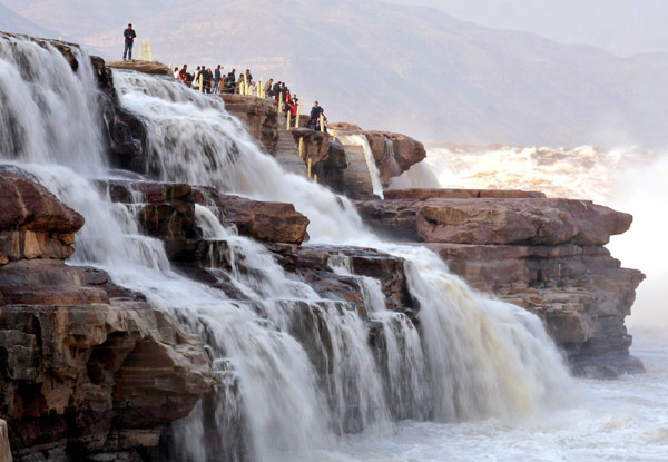 Tourists view Hukou Waterfall on Yellow River