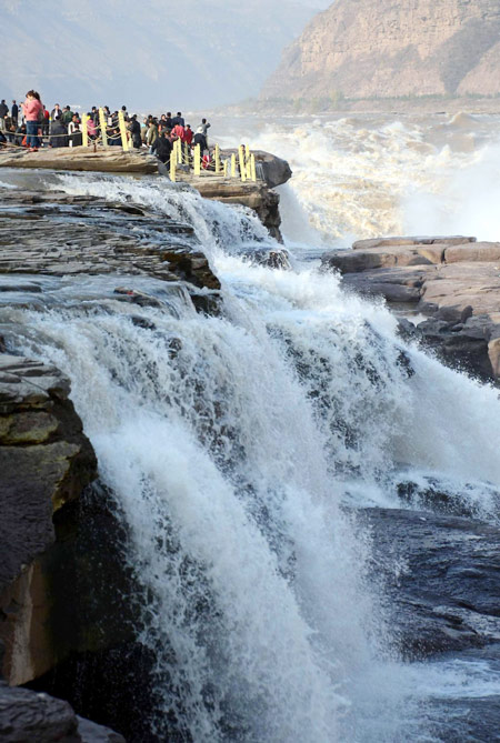 Tourists view Hukou Waterfall on Yellow River