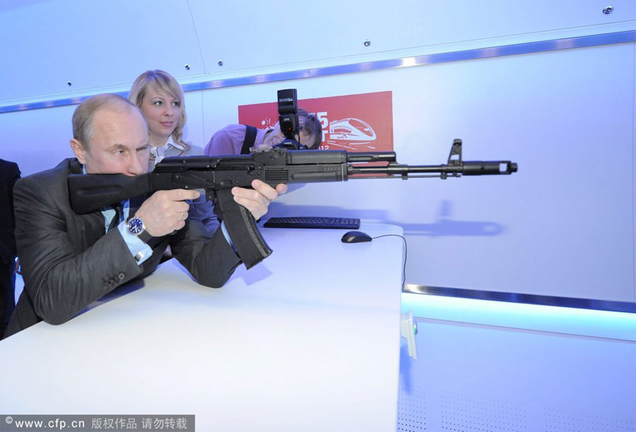 Vladimir Putin takes aim with a mock AK-47 submachine-gun in the electronic shooting gallery while visiting the Russian Railways Company's Research and Technological Center in Moscow, April 26, 2012. Photo special: Russia's man in action