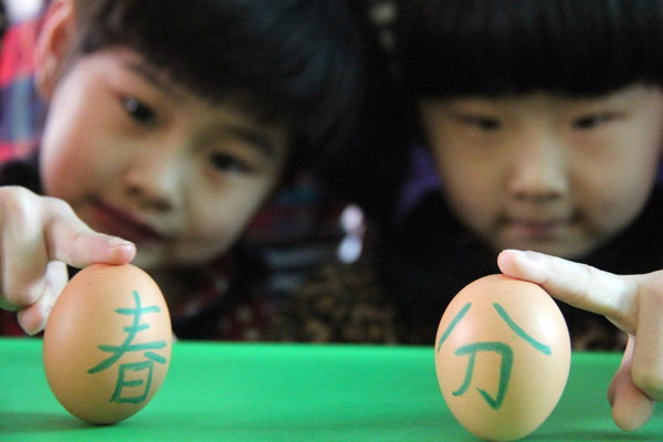 Children stand up eggs to mark Chinese festival