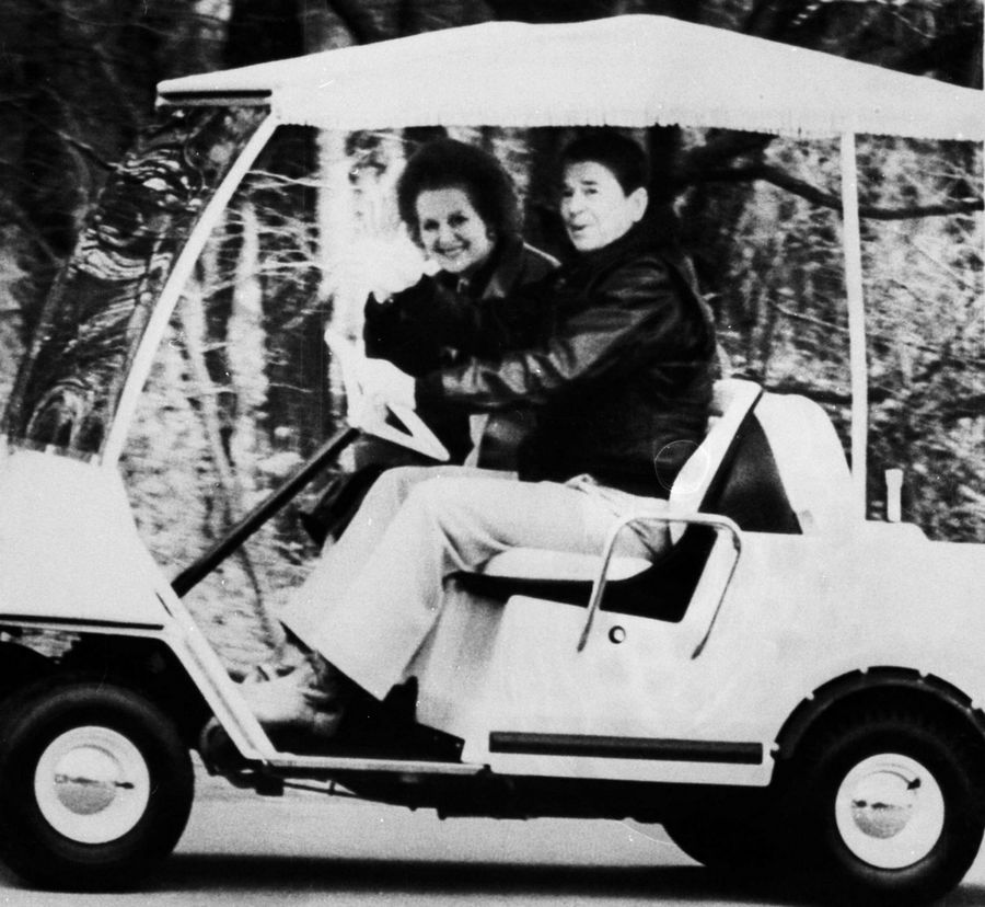 Then US President Ronald Reagan drives then British Prime Minister Margaret Thatcher (L) toward their meeting in Camp David in this November 15, 1986 file photo, after her arrival by helicopter from Washington. Margaret Thatcher with politicians