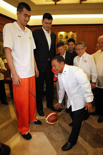 Philippine Vice-President Jejomar Binay (C) dribbles a ball in front of visiting former National Basketball Association (NBA) player and owner of the Shanghai Dongfang Sharks Yao Ming (2nd L), during a visit to the Coconut Palace in Manila May 6, 2013. Yao Ming and Shanghai Sharks on friendly visit in Manila