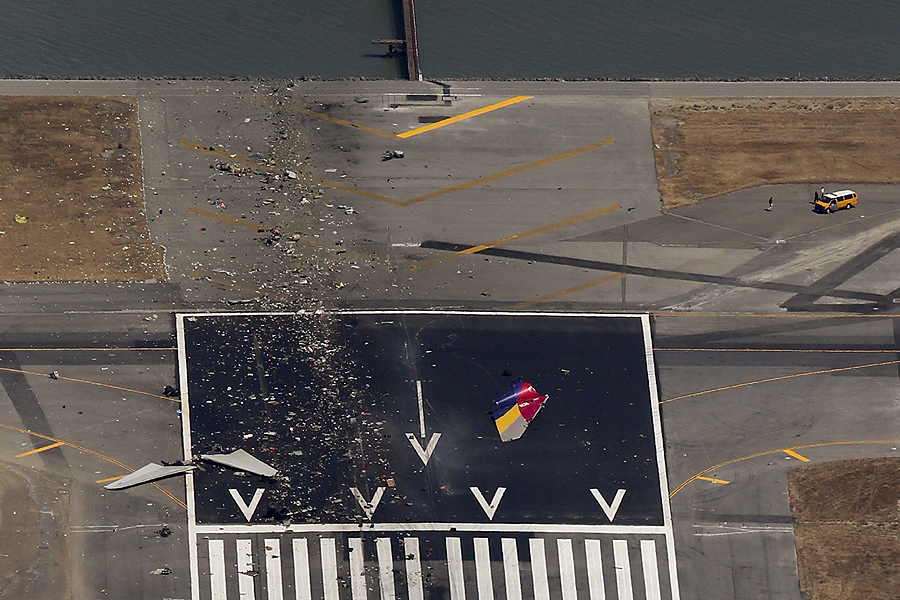 Debris from an Asiana Airlines Boeing 777 plane is seen on a runway after it crashed while landing at San Francisco International Airport in California on July 6, 2013. The plane, with 307 people on board, crashed and burst into flames as it landed at San Francisco International Airport on Saturday after a flight from Seoul, and initial reports said two people were killed and more than 130 sent to hospitals. Asiana flight crashes at SFO