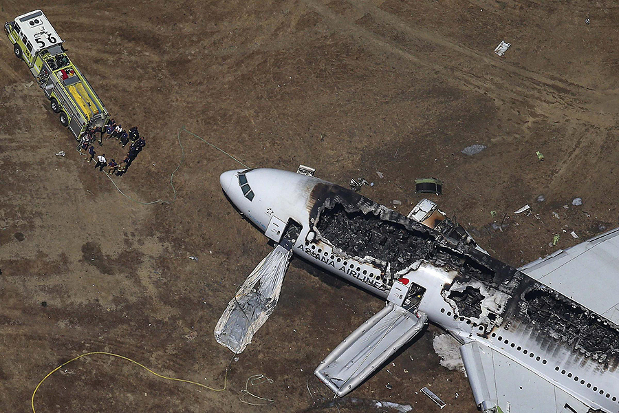 Rescue officials stand near an Asiana Airlines Boeing 777 plane after it crashed while landing at San Francisco International Airport in California on July 6, 2013. Two people were killed and 130 were hospitalized after the plane crash-landed at San Francisco International Airport on Saturday morning, San Francisco Fire Department Chief Joanna Hayes-White said. The figures cited by Hayes-White leave 69 people still unaccounted for in the accident. The Boeing 777, which had flown from Seoul, South Korea, was carrying 307 people. Asiana flight crashes at SFO