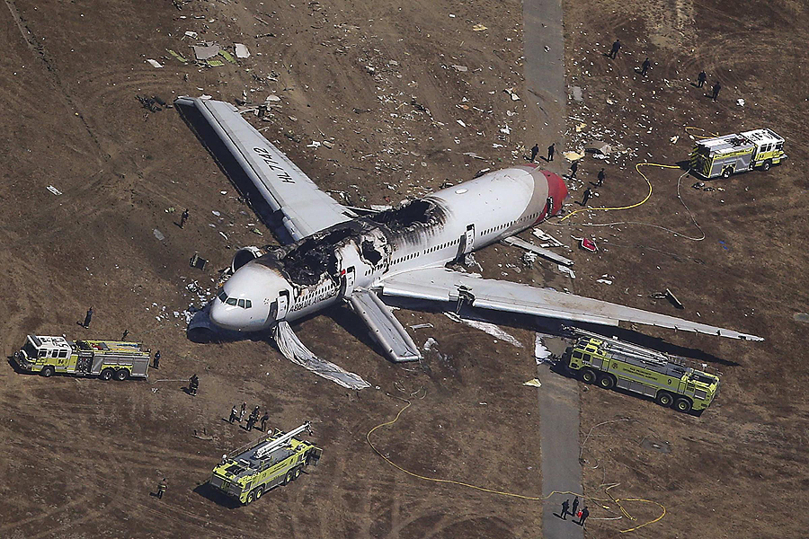 Search and rescue officials surround an Asiana Airlines Boeing 777 plane after it crashed while landing at San Francisco International Airport in California on July 6, 2013. The plane with more than 300 people on board crashed on Saturday while landing at San Francisco airport after a flight from Seoul and burst into flames. Two people were reported killed and 73 to 103 injured in the crash landing, a San Francisco city fire department dispatcher said. Asiana flight crashes at SFO