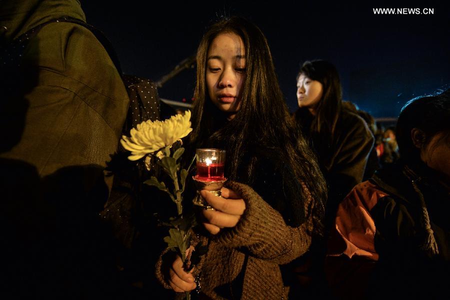 People hold candles to mourn victims of Nanjing Massacre