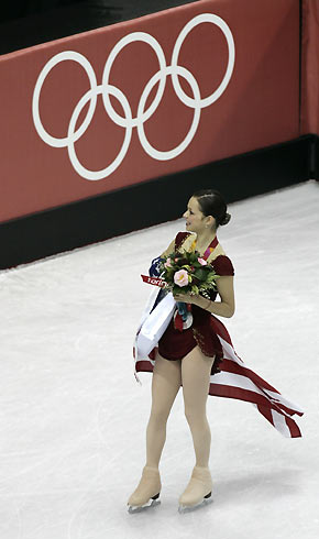 Silver medal winner Sasha Cohen of the U.S. covers herself with a national flag after the women's Figure Skating competition at the Torino 2006 Winter Olympic Games in Turin, Italy, February 23, 2006. Shizuka Arakawa of Japan won gold and Irina Slutskaya of Russia won the Bronze. [Reuters]