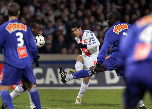 Olympique Lyon's Juninho (C) kicks the ball in front of players from SC Bastia during their French Cup soccer match at the Gerland stadium in Lyon March 21, 2006. Lyon qualified 1-0. [Reuters]