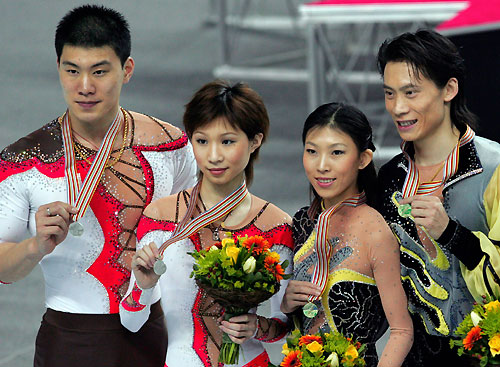 Silver medallist Zhang Hao (L) and Zhang Dan (2nd L) of China stand with their gold medal winning compatriots Pang Qing and Tong Jian (R) at the World Figure Skating Championships in Calgary, Canada, March 22, 2006. [Reuters]