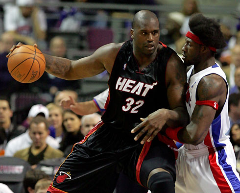 Miami Heat center Shaquille O'Neal (L) drives against Detroit Pistons center Ben Wallace during the second half of their NBA game in Auburn Hills, Michigan, March 22, 2006. [Reuters]
