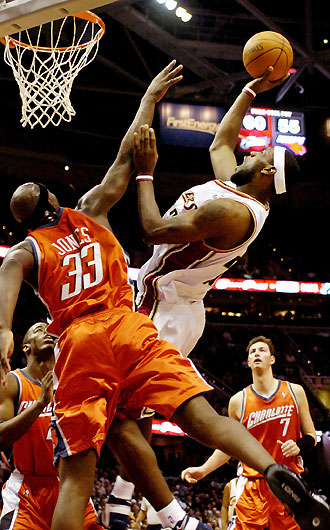 LeBron James (C) of the Cleveland Cavaliers goes up for a shot guarded by Jumaine Jones 