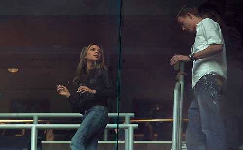Victoria Beckham (L), wife of Real Madrid's David Beckham, takes her seat as an unidentified man follows during the Spanish first division soccer match between Real Madrid and Deportivo Coruna at the Santiago Bernabeu stadium in Madrid March 26, 2006. [Reuters]