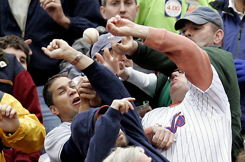 Fans above first base try to catch a foul ball during the opening day game between the Washington Nationals and the New York Mets at Shea Stadium in New York April 3, 2006. The Mets won the game 3-2.