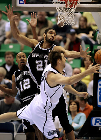 Utah Jazz forward Mehmet Okur of Turkey (R) goes after a rebound against San Antonio Spurs defenders Tim Duncan (C) and Bruce Bowen (L) during 
