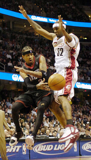 Allen Iverson of the Philadelphia 76ers passes the ball off around Larry Hughes (32) of the Cleveland Cavaliers during the fourth quarter 