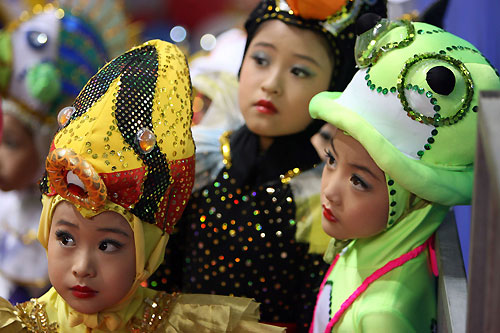 Students watch the competition during the 8th FINA World Short Course Swimming Championships in Shanghai April 6, 2006. [Reuters