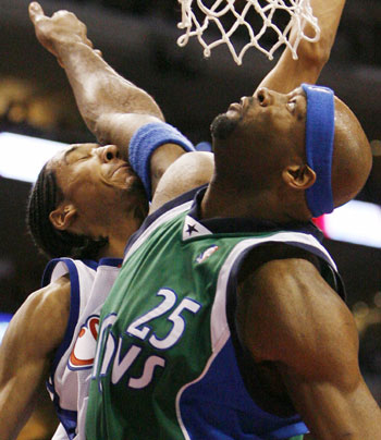 Los Angeles Clippers Shaun Livingston (L) is hit in the face by Dallas Mavericks Erick Dampier (R) as he shoots during the second half of NBA basketball action in Los Angeles, April 10, 2006.