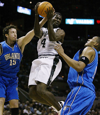 Spurs guard Michael Finley (C) gets fouled by Orlando Magic's Hedo Turkoglu (L) as 