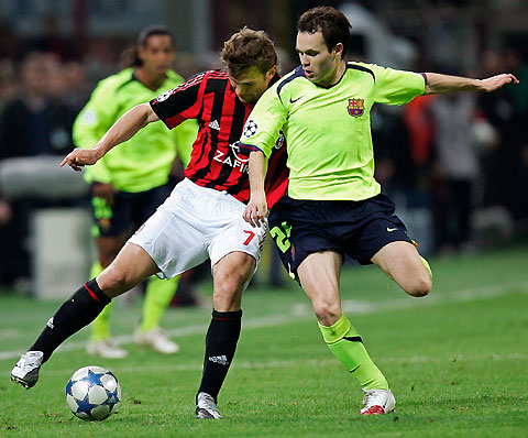 Milan's Andriy Shevchenko (L) challenges Barcelona's Andres Iniesta