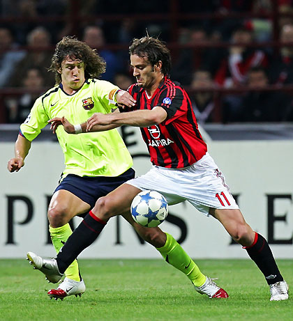 Alberto Gilardino (R) challenges Barcelona's Carles Puyol