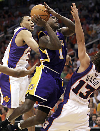 Angeles Lakers guard Smush Parker (C) drives to the basket between Phoenix Suns forward Shawn Marion (L) and guard Steve