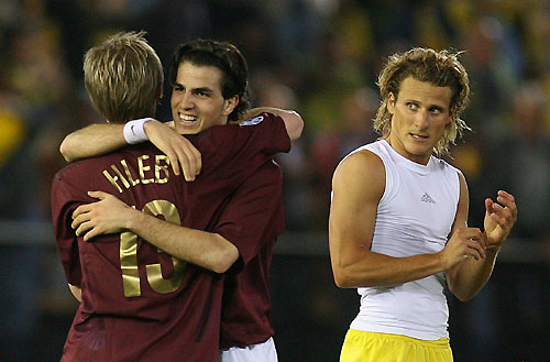 Arsenal's Cesc Fabregas (C) celebrates with Alexander Hleb (L) and are watched by Villarreal's Diego Forlan (R) after the second leg of