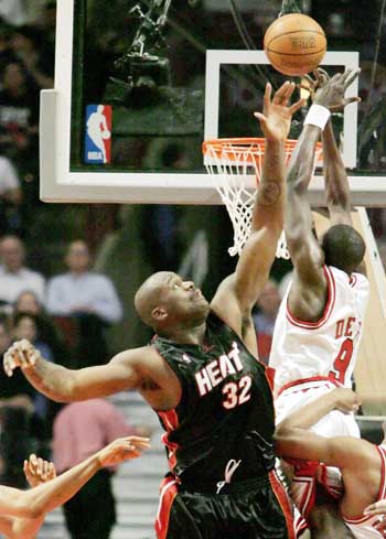 Miami Heat center Shaquille O'Neal (L) blocks the shot of Chicago Bulls forward Luol Deng in the second quarter of their NBA Eastern Conference quarterfinal game in Chicago April 27, 2006. 