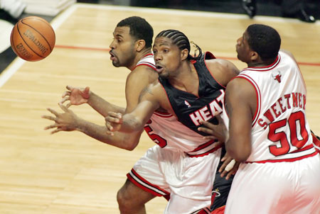 Miami Heat forward Udonis Haslem (C) puts up a shot between Chicago Bulls forwards Malik Allen (L) and Michael Sweetney in the first quarter of their NBA Eastern Conference quarterfinal game in Chicago April 27, 2006.