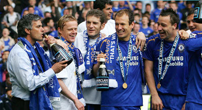 Chelsea's manager Jose Mourinho (L) drinks from a champagne bottle as Damien Duff (2nd L), Arjen Robben (2nd R) and John Terry (R) look on after winning the English Premier League and their soccer match against Manchester United at Stamford Bridge in London, April 29, 2006. 