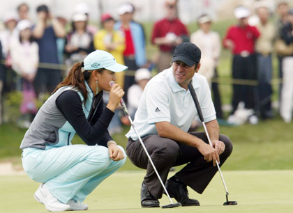 American golfer Michelle Wie (L) talks with Australia's Terry Pilkadaris on the 4th hole on the second day of SK Telecom Open 2006 at the Sky 72 Golf Club in Inchon, west of Seoul, May 5, 2006.