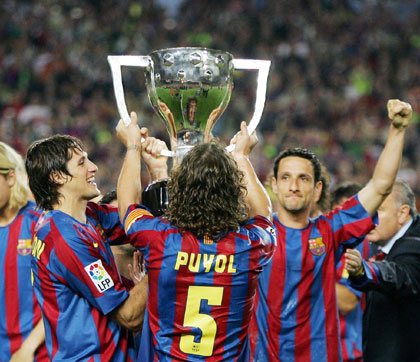 Barcelona's Edmilson, Carles Puyol and Juliano Belletti (L-R) hold the championship trophy after their Spanish First Division soccer match against Espanyol at Nou Camp in Barcelona, Spain, May 6, 2006.