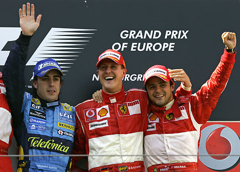 Schumacher of Germany receives congratulations from his Ferrari team while followed by second placed Renault's F1 World Champion Fernando Alonso