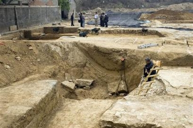 Chinese officials from the antiquities bureau are seen near the uncovered imperial-era tombs at the construction site of a shooting range for the 2008 Beijing Olympic Games where work has been suspended in Beijing, China, Monday, May 8, 2006.
