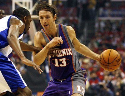 Phoenix Suns' Steve Nash (R) dribbles the ball under pressure from Los Angeles Clippers' Quinton Ross during the first quarter in Game 3 of their NBA Western Conference Playoff semifinal series in Los Angeles May 12, 2006. [Reuters]