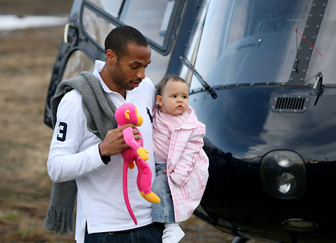 French soccer star Thierry Henry of Arsenal (R) holds his daughter Tea as he arrives by helicopter at Tignes ski resort in French Alps, May 21, 2006. All 23 players of the national team arrived today in Tignes for a 4-day training session in preparation for the upcoming World Cup in Germany.