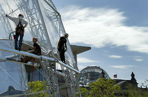 Workers climb at the construction site of the 'Bundestagsarena' in front of the dome of the Reichstag building, the seat of the German lower house of parliament Bundestag in Berlin May 22, 2006. An information centre will be located at the Bundestagsarena to present the work of the German parliament from June 7 to July 9, 2006. 