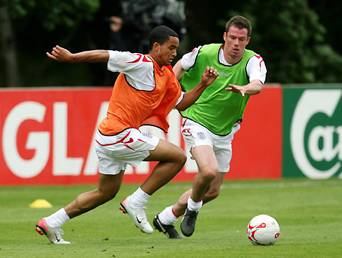 England's Theo Walcott (L) is marked by Jamie Carragher during a squad training session in Watford, north of London, May 22, 2006. 