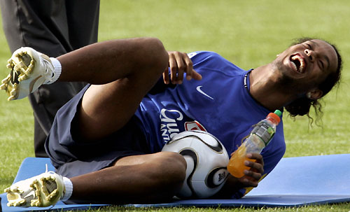 Brazilian striker Ronaldinho laughs after a fan ran onto the pitch to embrace him during a training session at Thermoplan Arena in Weggis, Switzerland, May 26, 2006.