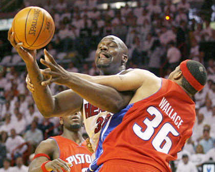 Miami Heat center Shaquille O'Neal (C) battles with Detroit Pistons' defender Ben Wallace in the second half during Game 6 of the NBA Eastern Conference Finals in Miami June 2, 2006.