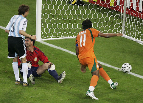 Ivory Coast's (11) Didier Drogba runs to pick up the ball after scoring against Argentina's goalkeeper Roberto Abbondanzieri (C) as Gabriel Heinze watches during their Group C World Cup 2006 soccer match in Hamburg 