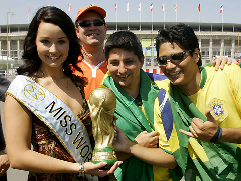 Miss World 2005 Unnur Birna Vilhjalmsdottir (L) of Iceland holds a copy of the World Cup trophy as she poses with Brazilian soccer fans in front of the Olympic Stadium in Berlin June 13, 2006. Brazil's national soccer team will play in a Group F match of the World Cup against Croatia later on Tuesday in Berlin.