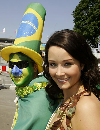 Miss World 2005 Unnur Birna Vilhjalmsdottir (L) of Iceland holds a copy of the World Cup trophy as she poses with Brazilian soccer fans in front of the Olympic Stadium in Berlin June 13, 2006. Brazil's national soccer team will play in a Group F match of the World Cup against Croatia later on Tuesday in Berlin.