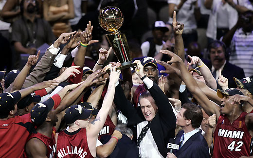 Miami Heat players and head coach Pat Riley (C) celebrate with the trophy after defeating the Dallas Mavericks in Game 6 of their NBA Finals basketball game in Dallas, Texas, June 20, 2006.