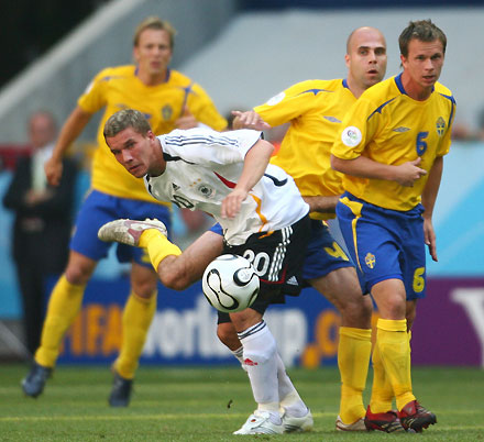 Germany's Lukas Podolski, Sweden's Teddy Lucic (C) and Tobias Linderoth (R) look at the ball during their second round World Cup 2006 soccer match in Munich June 24, 2006.