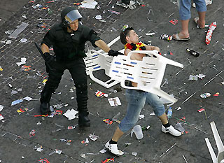 A soccer fan throws a chair beside German riot police after violence broke out between German and England soccer fan in the centre of Stuttgart