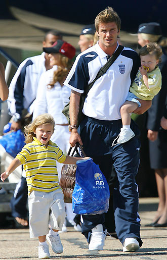 England's former captain David Beckham (L) arrives from Germany with wife Victoria (R) and sons Cruz (2nd L), Romeo (C) and Brooklyn at Stansted airport near London on July 2, 2006. [Reuters]