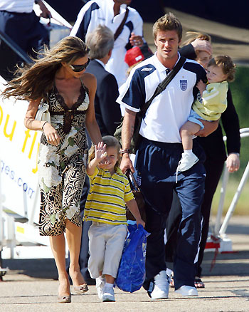England's former captain David Beckham (L) arrives from Germany with wife Victoria (R) and sons Cruz (2nd L), Romeo (C) and Brooklyn at Stansted airport near London on July 2, 2006. [Reuters]