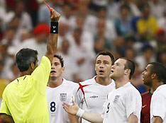 Referee Horacio Elizondo of Argentina shows England's Wayne Rooney (2nd R) a red card as Rooney's team mates react during their World Cup 2006 quarter-final soccer match against Portugal in Gelsenkirchen July 1, 2006.